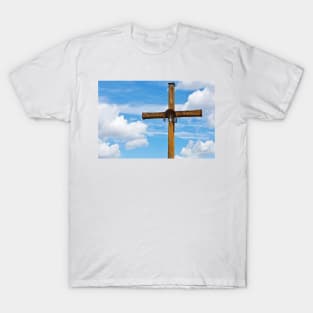 Figurine of Jesus Christ on a wooden cross against under blue cloudy sky T-Shirt